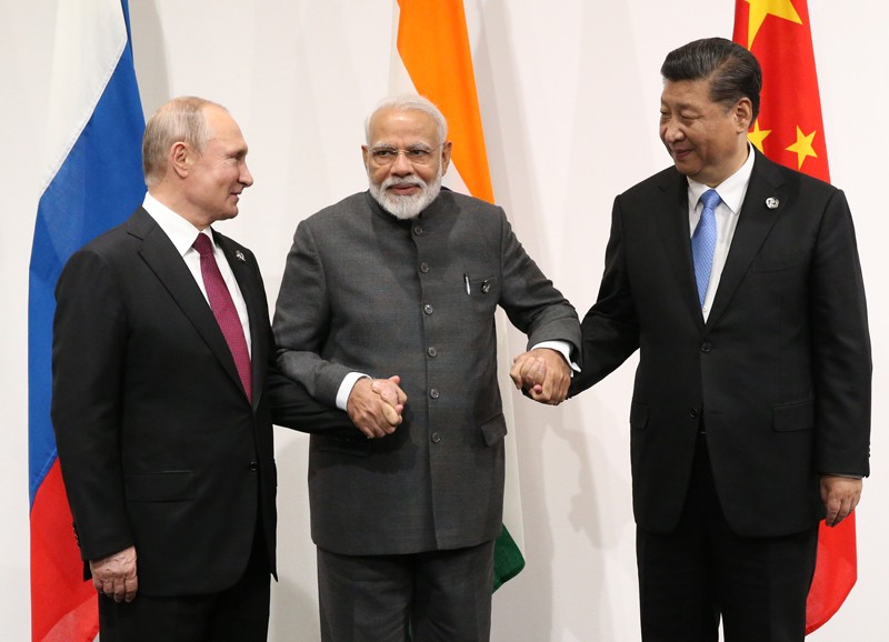 Narendra Modi holds the hands of Vladimir Putin and Xi Jinping at the 2019 G20 summit