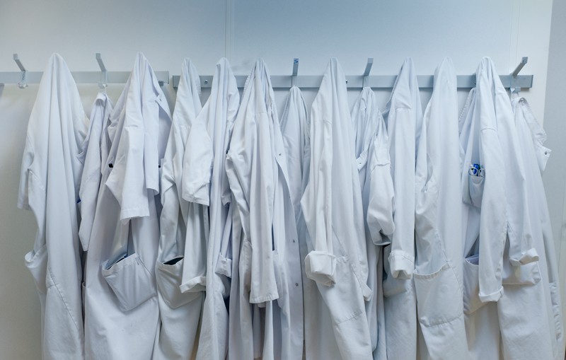 White lab coats hanging from hooks at a laboratory