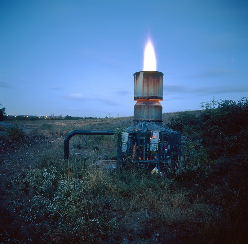 A landfill site in Northfleet, Kent, England, with a methane gas flare burning.