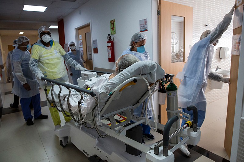 Health workers move a COVID-19 patient to a ward of Dr. Ernesto Che Guevara hospital in Marica, Brazil.
