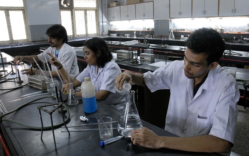 Oppilaat työskentelevät kemian laboratoriossa Ramnarain Ruia Collegessa Mumbaissa.