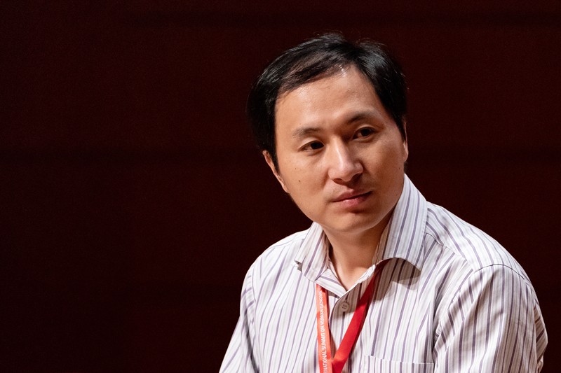 He Jiankui listens during a panel discussion in 2018