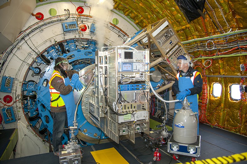Technicians introduce liquid nitrogen into an instrument connected to the SOFIA telescope to remove as much heat as possible.