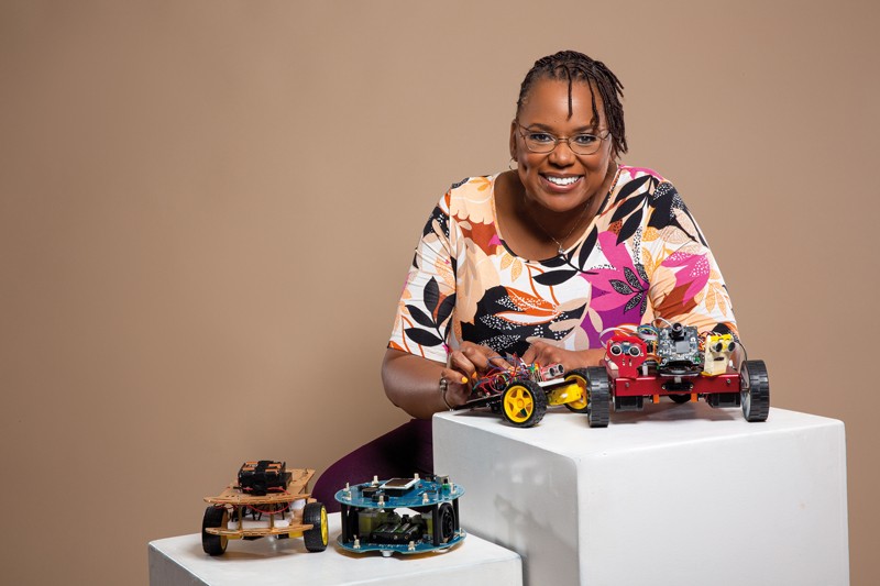 Carlotta Berry posing for a portrait with some programmable vehicles