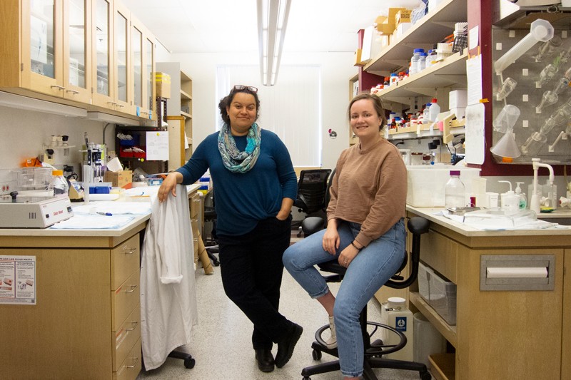 Mariya Sweetwyne and Carolyn Mann pose for a portrait in a laboratory