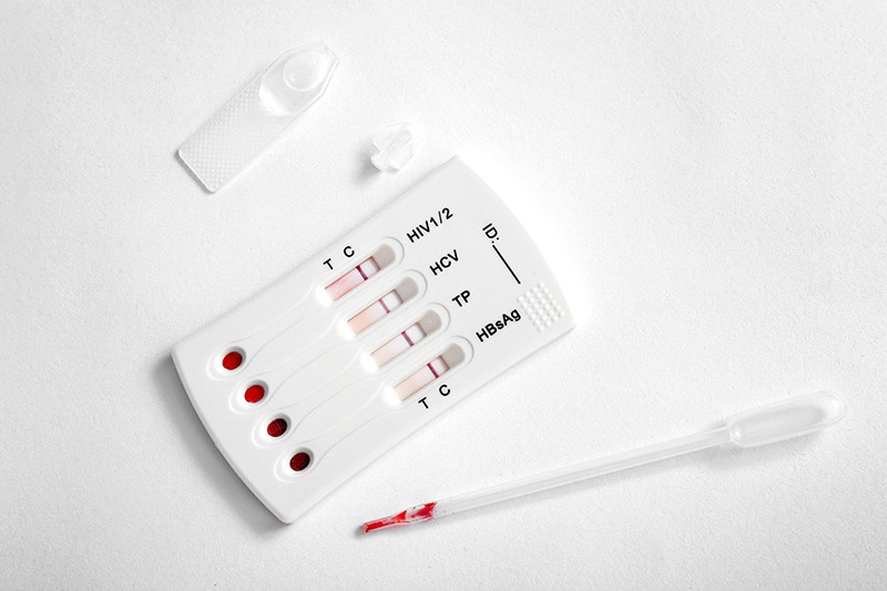 Blood-drop test kit for HIV, hepatitis B, hepatitis C and syphilis, on white background.