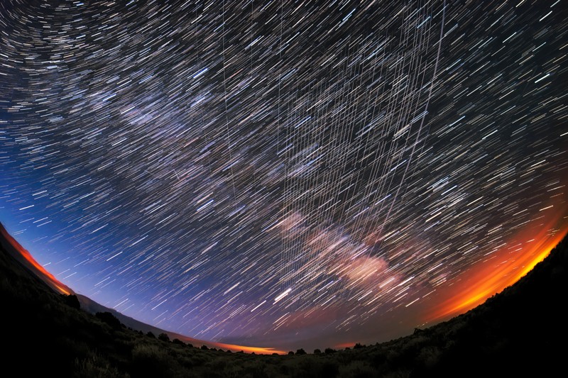 Une vue super grand angle des satellites Starlink traversant un ciel nocturne