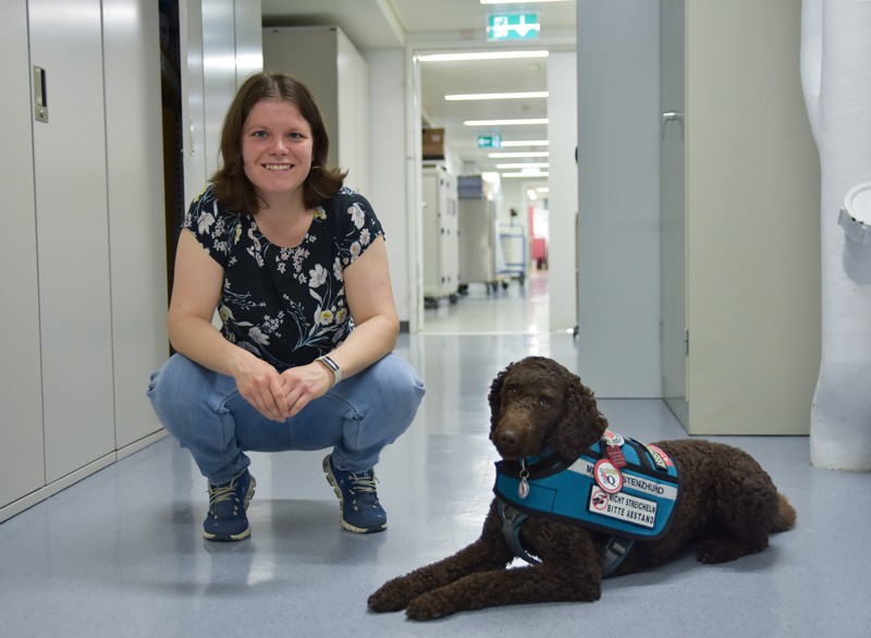 Ronja Weber poses for a photograph with her assistance dog in the corridor outside her lab
