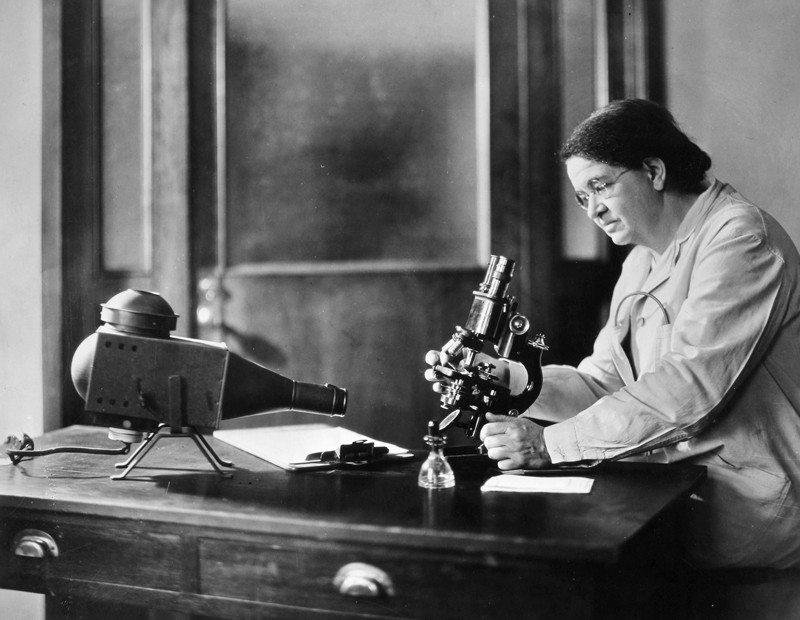 Historical black and white image of Florence Sabin working with a microscope