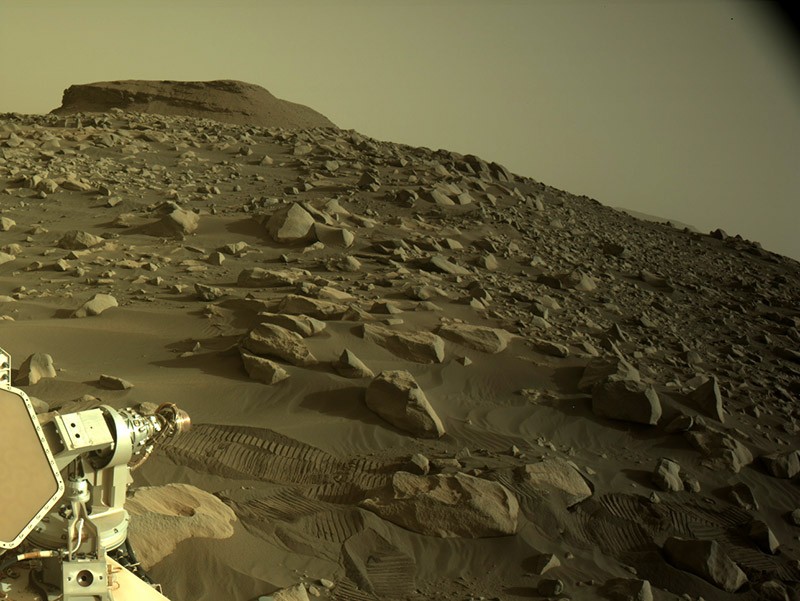 NASAの火星の忍耐力のあるローバーによって捕らえられた三角州に向かって岩だらけの火星の風景の眺め。