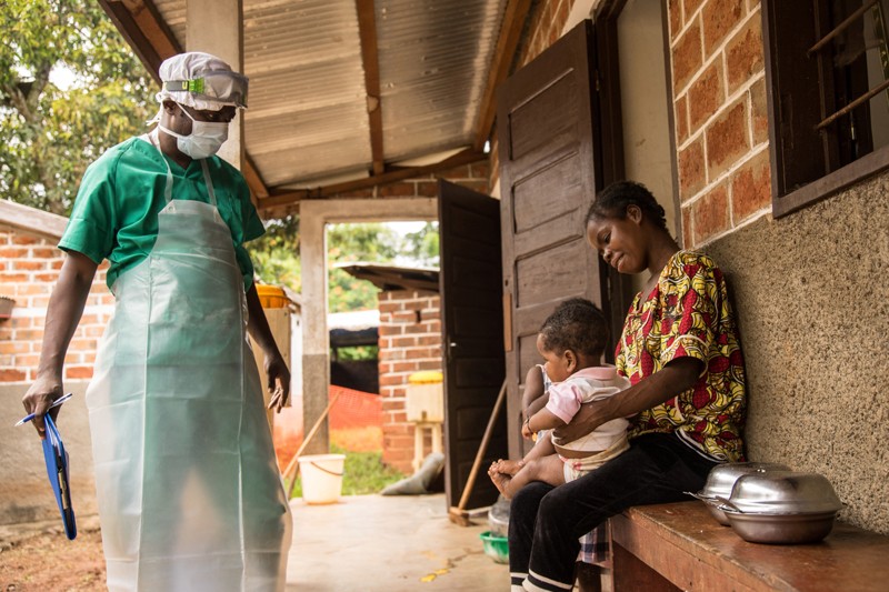 A health worker in PPE talks to a woman and her baby who have been infected with monkeypox in Central African Republic 2018