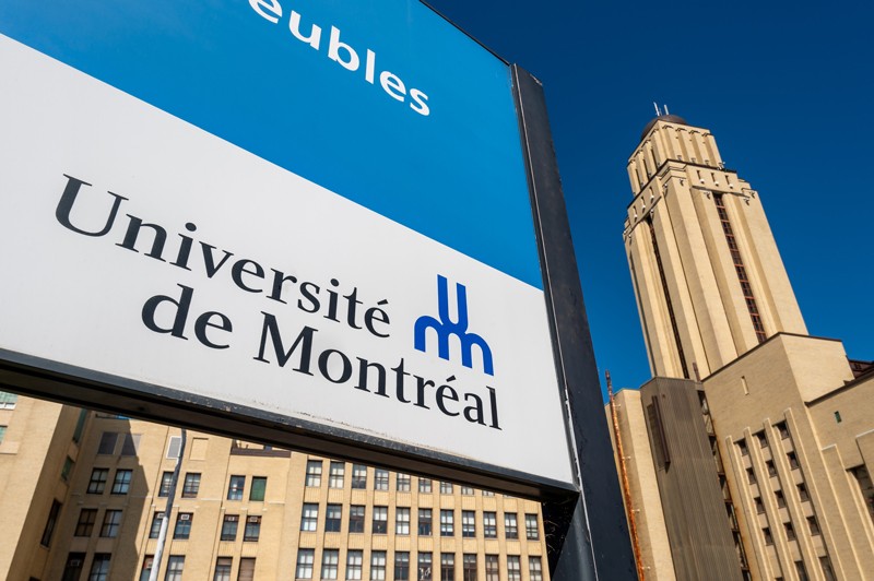 Low-angle close up of the University of Montreal sign with the building in the background