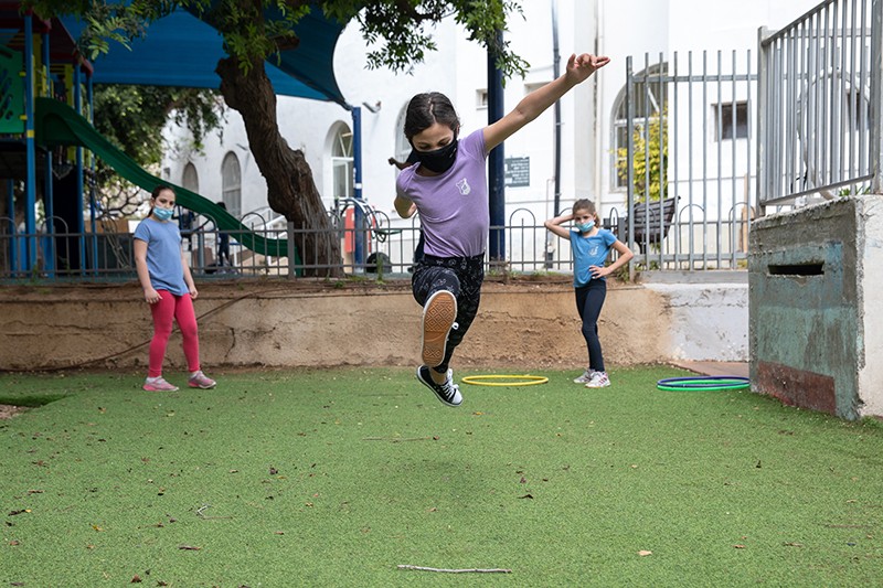 Third grade children play on the first day of school after over a month and a half of school closures in Tel Aviv, Israel.