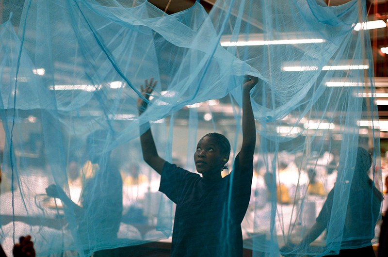 A worker searches for holes in a mosquito net at A to Z Textile Mills in Arusha, Tanzania.