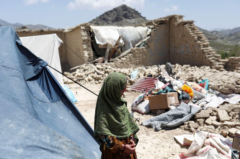 A girls stands in the ruins of her house which was destroyed by an earthquake in Afghanistan