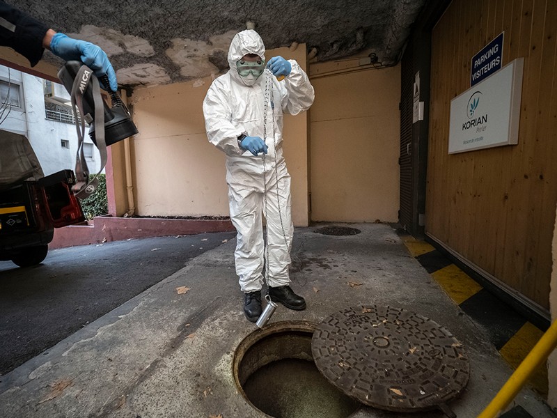 A firefighter, wearing a protective suit, takes a sample of sewage water from Marseille, France.