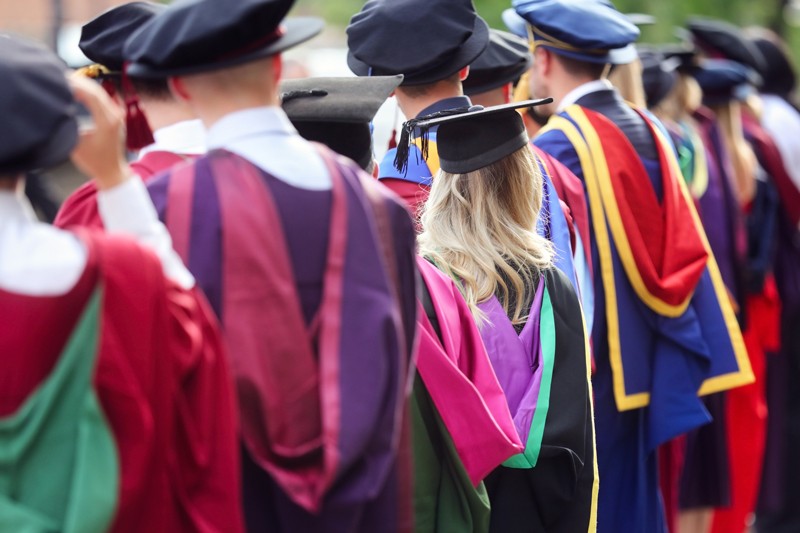 Graduates at university graduation ceremony wearing colourful gowns