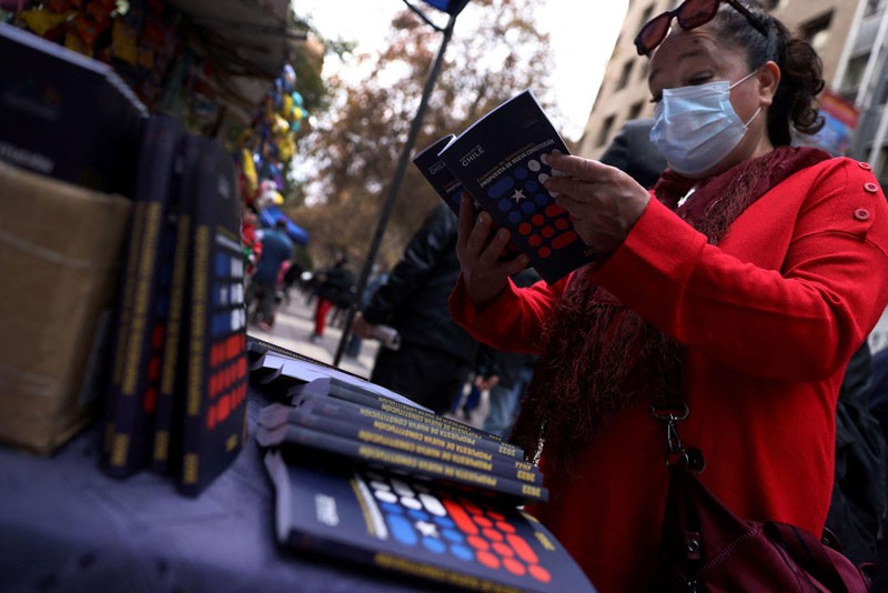 Eine Frau liest eine Kopie der vorgeschlagenen neuen chilenischen Verfassung, die an einem Marktstand in Santiago verkauft wird