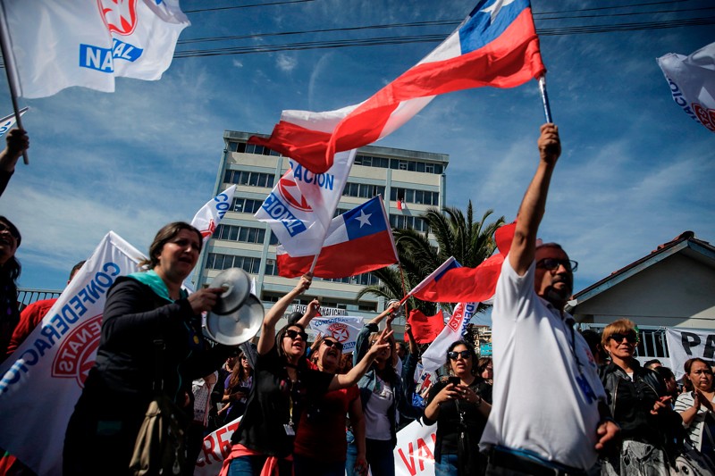 People wave the flag of Chile during demonstrations against increasing living costs and social inequality in October 2019