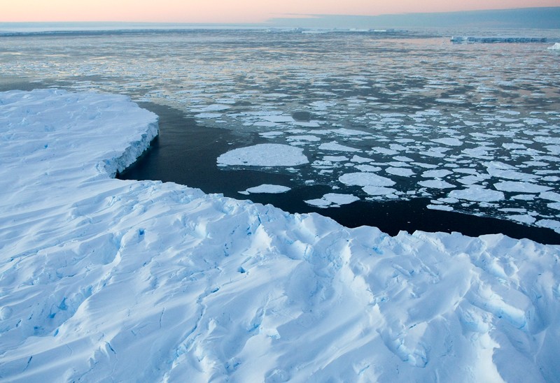 ภูเขาน้ำแข็งแบบตารางขนาดยักษ์ที่รายล้อมไปด้วยน้ำแข็งที่ลอยอยู่ในอ่าว Vincennes ทางตะวันออกของแอนตาร์กติกา