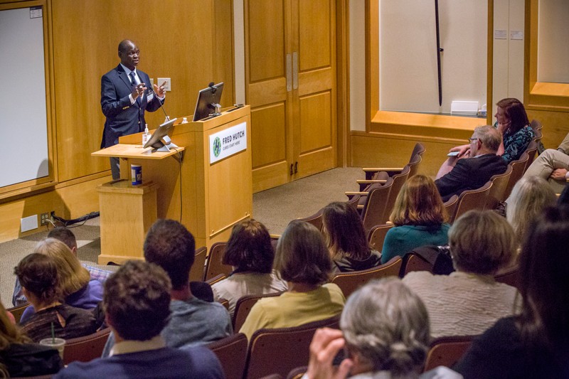 Jackson Orem delivers a speech to an audience in a lecture theatre at the Fred Hutchinson Cancer Research Center in Seattle