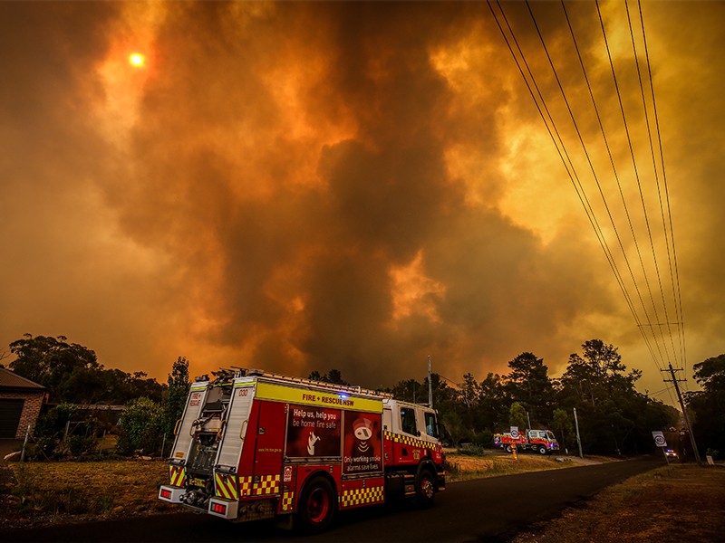 Firemen prepare as a bushfire approaches homes on the outskirts of the town of Bargo on December 21, 2019 in Sydney.