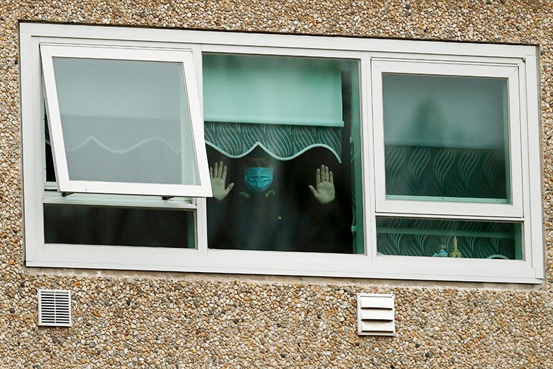 A man looks out a window of a housing complex during a mandatory lockdown on 6 July 2020 in Melbourne, Australia.