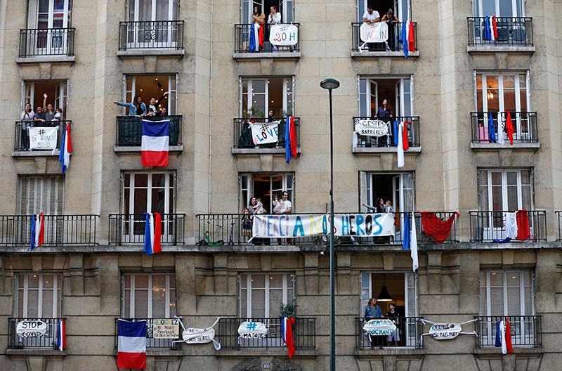People applaud on their balcony decorated with French flags in support of medical workers during a 2020 lockdown in Paris.