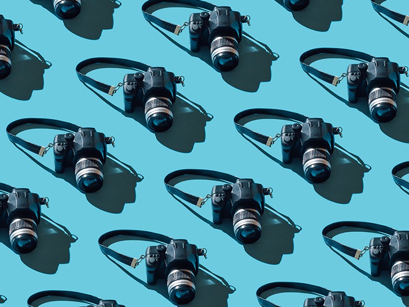 Pattern of cameras on blue background.