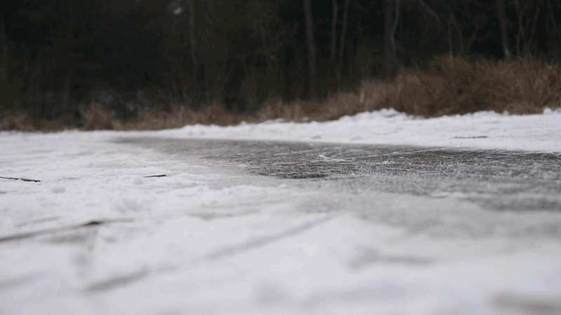 Young man slides and falls on frozen lake
