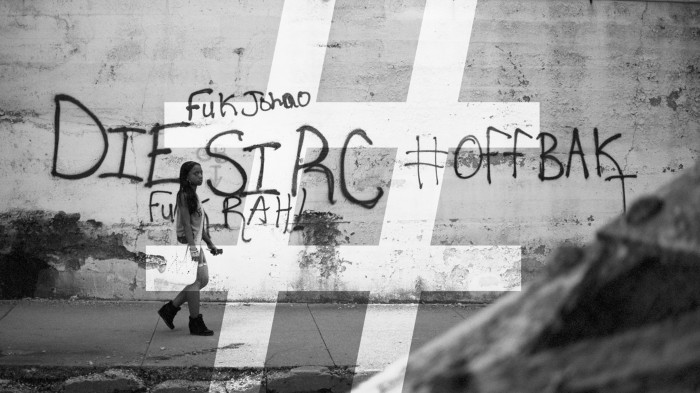 Girl walking past gang-related graffiti in Chicago