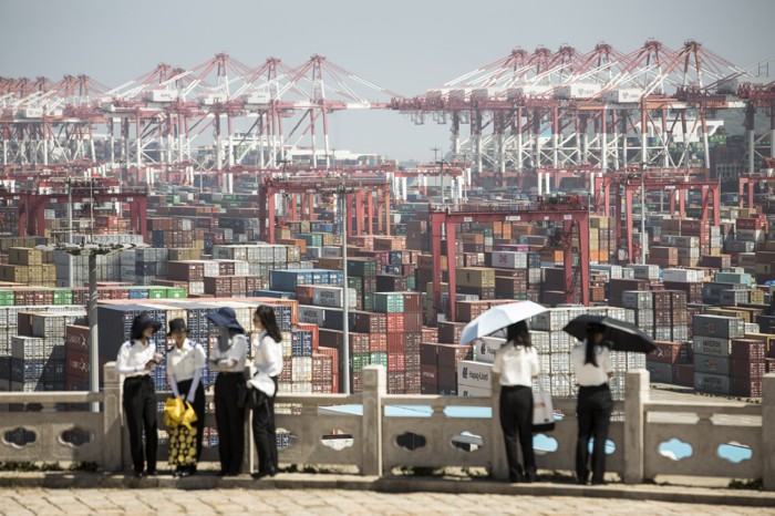 Students from the Shanghai Customs College stand at a viewing platform overlooking the Yangshan Deep Water Port in Shanghai