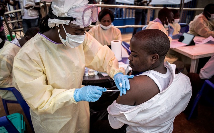 A health worker vaccinates a man against the ebola virus on June 16, 2019 in Butembo