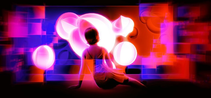Artistic image of a young girl sitting on the floor with her back to the viewer looking at some glowing alien globes