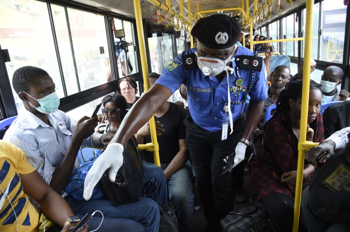 Lagos Commissioner of Police wears protective face mask and gloves while trying to enforce social distancing on a crowded bus