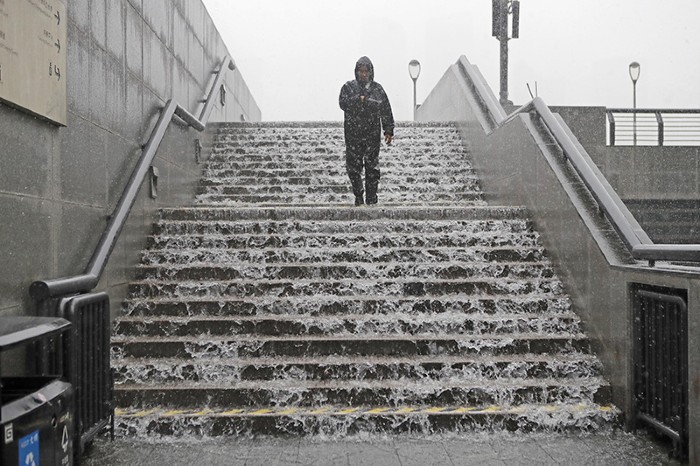 A worker inspects waterlogged steps on July 6, 2020 in Shanghai, China during a yellow alert for rainstorms.