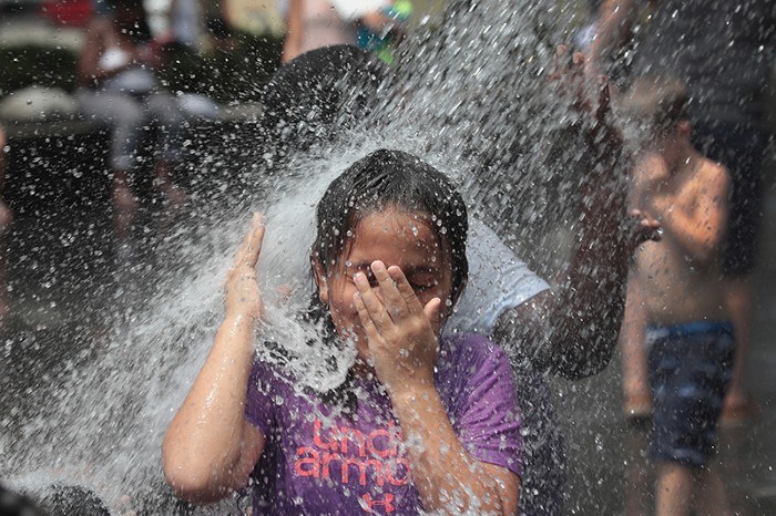 A child cools off in a fountain as the heat index was expected to reach 115 degrees on July 19, 2019 in Chicago, Illinois.