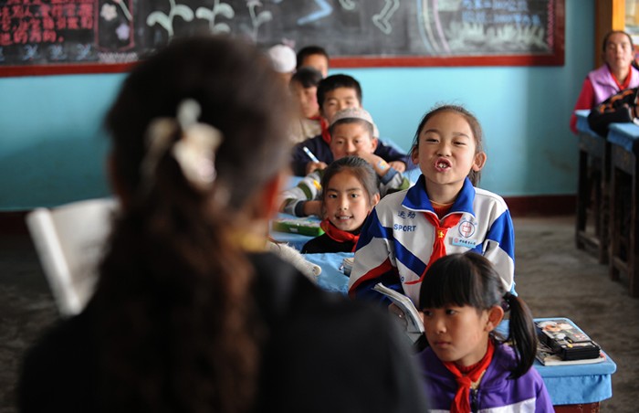 A classroom of fourth grade students studying maths with their teacher at Zhongyin Xiwang Primary School, China.