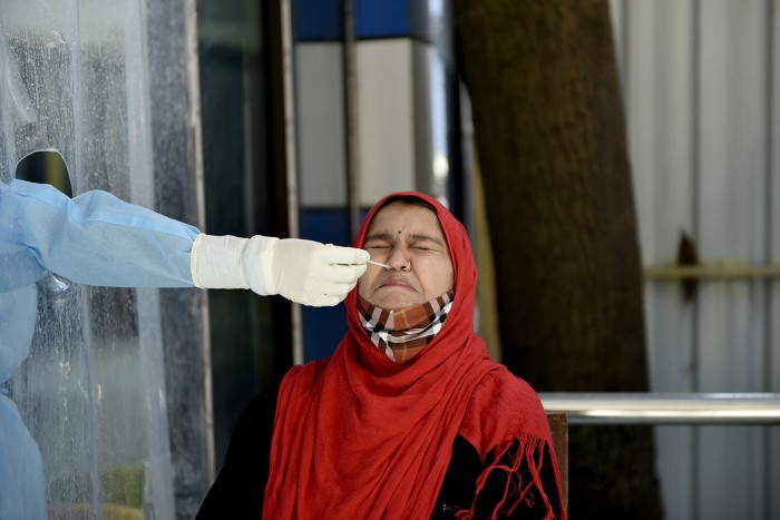 A health worker swabs a person's nose during a rapid antigen test for coronavirus in Kolkata, India, January 2022.