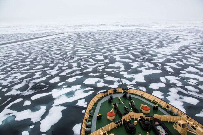The bow of an icebreaker in the Arctic ocean cruising forward in pack ice.