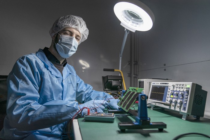 Julián Fernández, in protective clothing, works on a satellite system at his own company Fossa Systems in Spain.