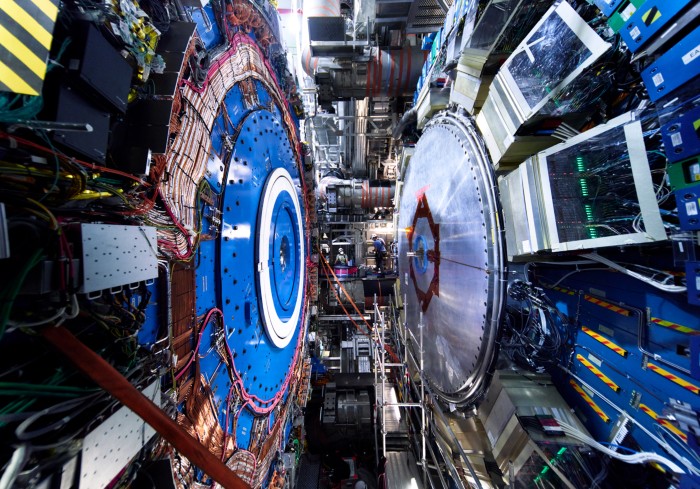 An engineers works between two massive wheels in the cavern of the ATLAS experiment at CERN during an upgrade in 2021