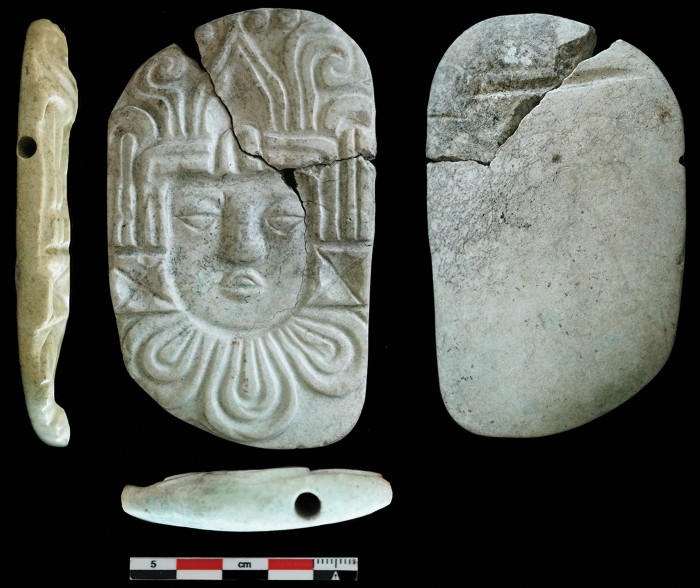 Carved pendant plaque of a human head from the burial.