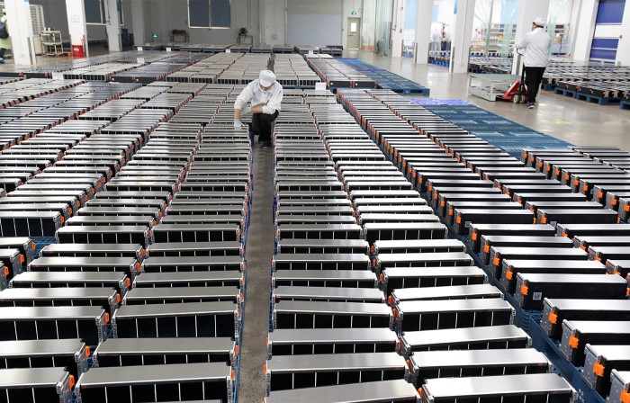 This photo taken on March 12, 2021 shows a worker with car batteries at a factory for Xinwangda Electric Vehicle Battery Co. Ltd, which makes lithium batteries for electric cars and other uses, in Nanjing in China's eastern Jiangsu province.