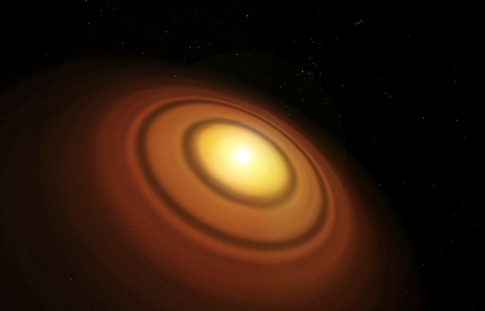 Illustration of the disc of protoplanetary material around the nearby young star TW Hydrae. Yellow core and orange rings on a black background.