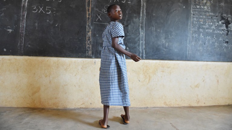 A girl stands at a blackboard in a rural school in Ivory Coast