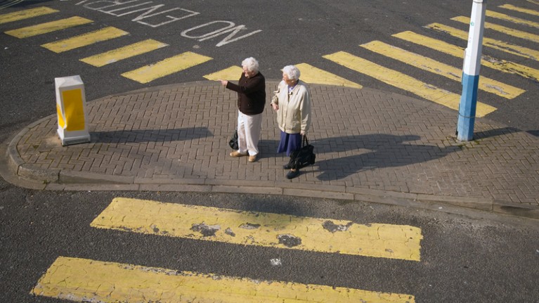 Two senior citizens crossing the road
