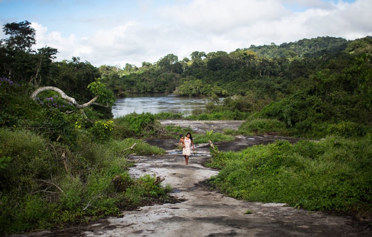 A woman walks through the Amazon forest