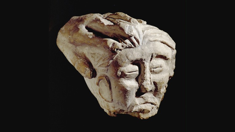 Celtic sculpture of a beheaded head, held by a hand