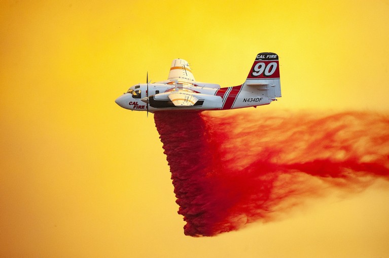 A plane drops fire retardant to help stop the spread of the River Fire burning in California.
